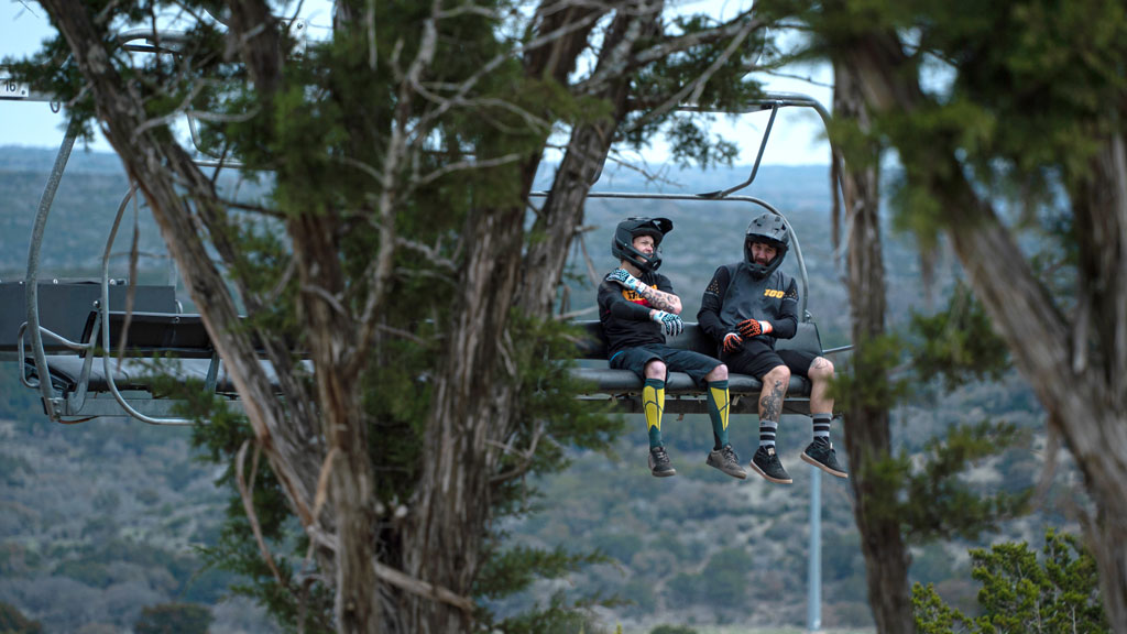 Two mountain bikers take the Spider Mountain Bike Park chairlift to the top, a relaxing way to prepare for the downhill thrill ride. Photo by Dakota Morrissiey