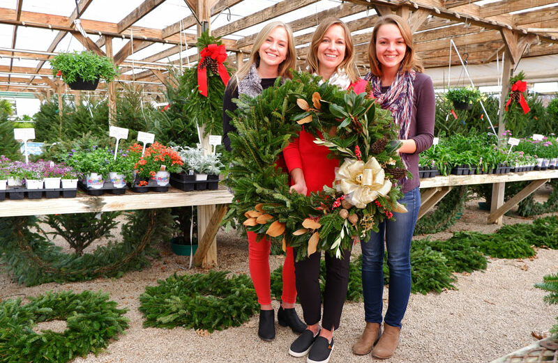 Using a mix of natural trimmings and some glitz and glitter, Karson Cain (left), mother Karin Cain, both of Marble Falls, and friend Paige Langum of College Station created a stunning holiday wreath at Backbone Valley Nursery in Marble Falls. Follow the steps below to make your own. Staff photos by David Bean.