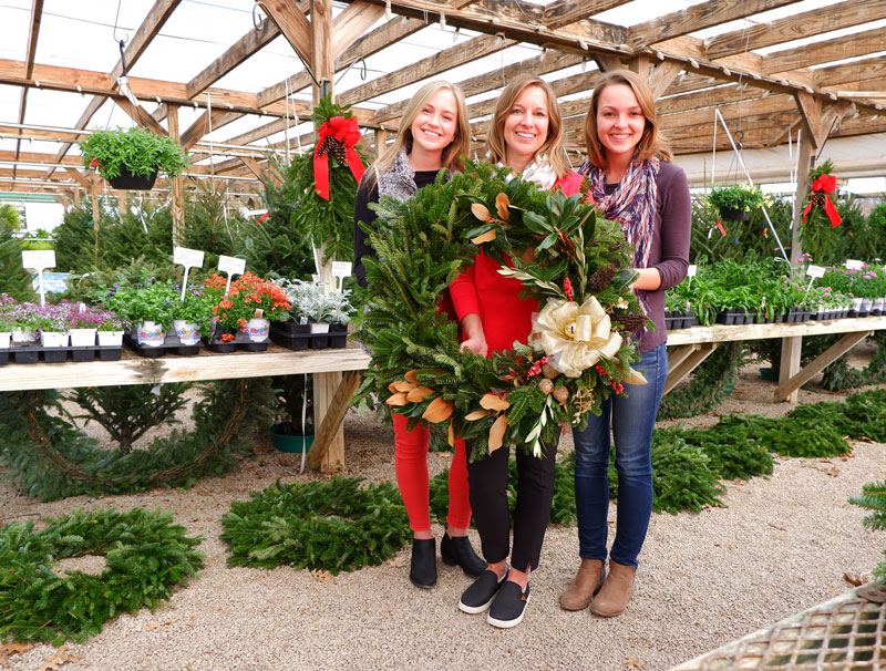 Using a mix of natural trimmings and some glitz and glitter, Karson Cain (left), mother Karin Cain, both of Marble Falls, and friend Paige Langum of College Station created a stunning holiday wreath at Backbone Valley Nursery in Marble Falls. Follow the steps below to make your own. Staff photos by David Bean.