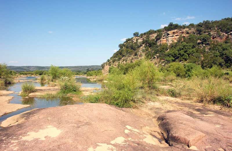 A cliff on the Llano River about a mile northwest of the Kingsland Slab is a scenic example of Highland Lakes geology. Staff photo by David Bean