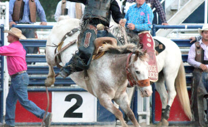 A saddle bronc rider hangs on tight during the Burnet County Rodeo. Photo by Erika Sopel