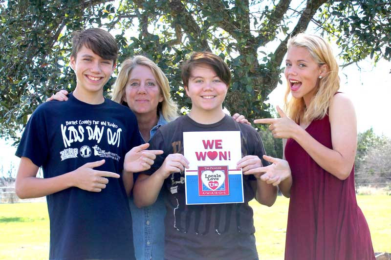 Martelle Luedecke (background) gives credit to her teenage children, J.P. (left), Samm, and Briezie, for her drive toward volunteerism, which led to her being voted Best Volunteer in the Burnet Area in The Picayune’s Locals Love Us awards. Courtesy photo