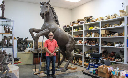 Smithwick artist Dan Pogue stands with his larger-than-life sculpture ‘Warriors,' which towers over him at 15 feet. Staff photo by JoAnna Kopp