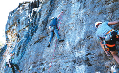 Nick Tran (left), Chancy Kennedy (center), and Adam Mitchell (right) each work different routes on the same limestone wall. Despite being so close to each other, the routes can vary in difficulty. Photo by Dakota Morrissiey