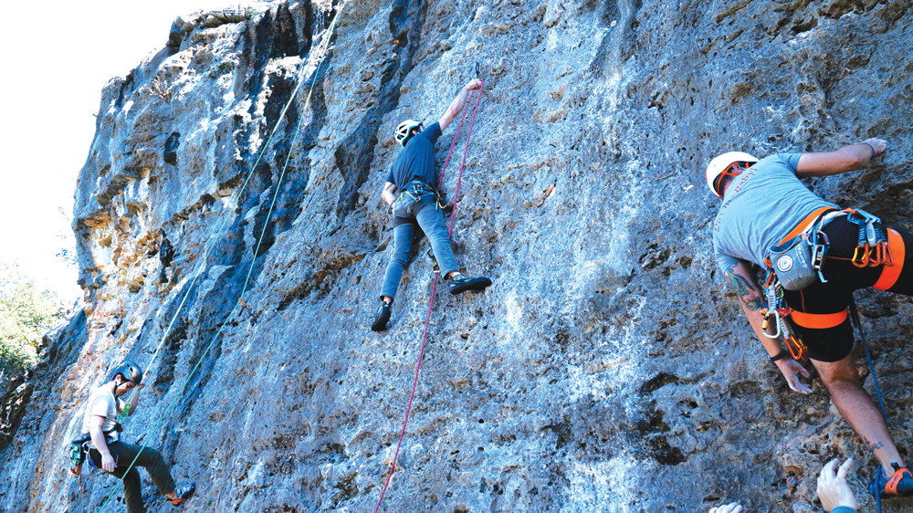 Nick Tran (left), Chancy Kennedy (center), and Adam Mitchell (right) each work different routes on the same limestone wall. Despite being so close to each other, the routes can vary in difficulty. Photo by Dakota Morrissiey