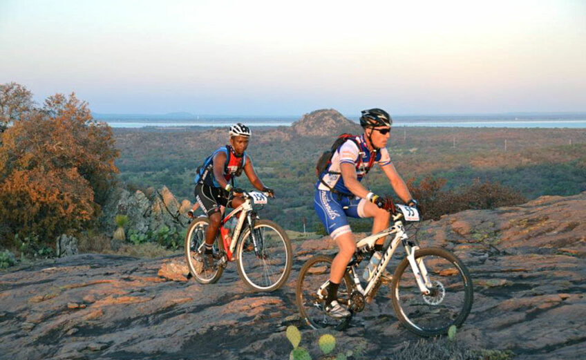 Two mountain bikers grind their way up the granite of Reveille Peak Ranch, 1,350 acres of outdoor paradise just 15 minutes from Burnet. Courtesy photo