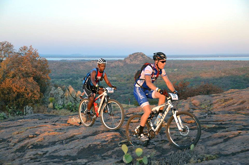 Two mountain bikers grind their way up the granite of Reveille Peak Ranch, 1,350 acres of outdoor paradise just 15 minutes from Burnet. Courtesy photo