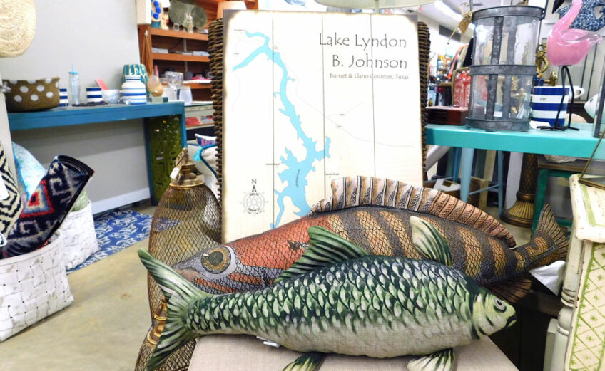 Included in the many Highland Lakes-inspired souvenirs at Ford & Crew Home Hardware are wooden wall maps of Lake LBJ and fish pillows. Staff photo by Jennifer Greenwell