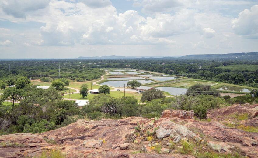 The view from the summit of the Overlook Trail showcases the region's iconic granite and the hatchery's pools where literal tons of channel catfish are raised. Staff photo by Dakota Morrissiey