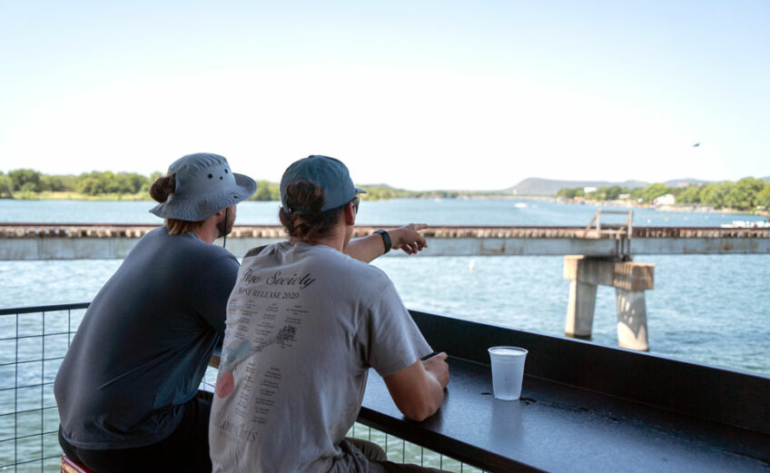 Tate Gregory and Matthew Smith, two vignerons from William Chris Vineyards in Hye, take their lunch break at Wakepoint LBJ in Kingsland. Wakepoint is a hotspot for boaters and Kingsland locals that overlooks the merging of the Colorado River, the Llano River, and Lake LBJ. Staff photo by Dakota Morrissiey