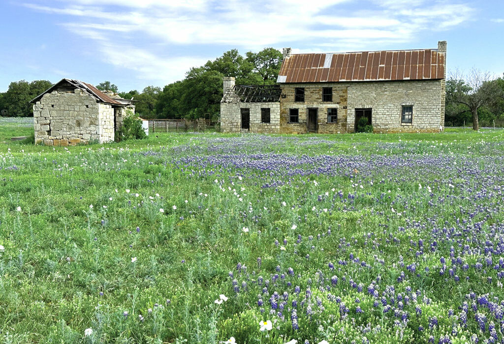 The Bluebonnet House in late March 2023, surrounded by bluebonnets. The Marble Falls structure is famous worldwide for its rich Texas history, architectural style, and iconic Hill Country landscape, especially during wildflower season. Staff photo by Suzanne Freeman