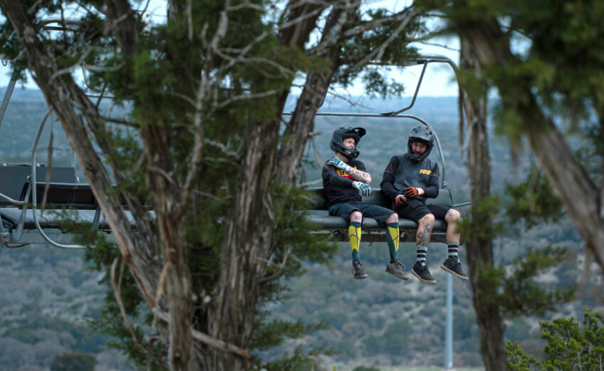 Two mountain bikers take the Spider Mountain Bike Park chairlift to the top, a relaxing way to prepare for the downhill thrill ride. Photo by Dakota Morrissiey