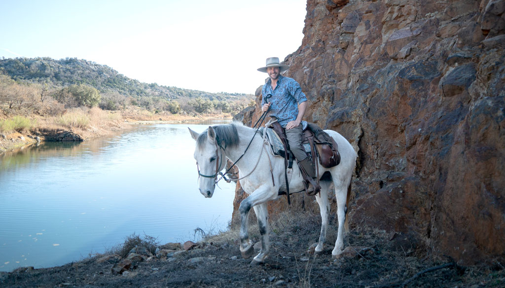 Travis Caffee of Thunder Horse Outfitters on Caspian, one of his many rescued horses, at Reveille Peak Ranch in Burnet. Staff photo by Dakota Morrissiey