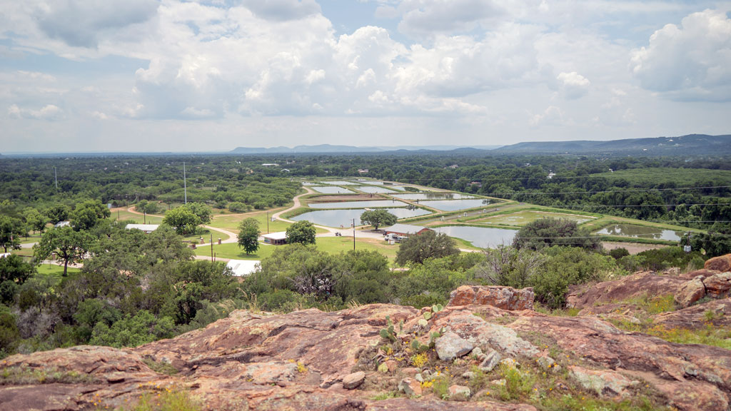 The view from the summit of the Overlook Trail showcases the region's iconic granite and the hatchery's pools where literal tons of channel catfish are raised. Staff photo by Dakota Morrissiey