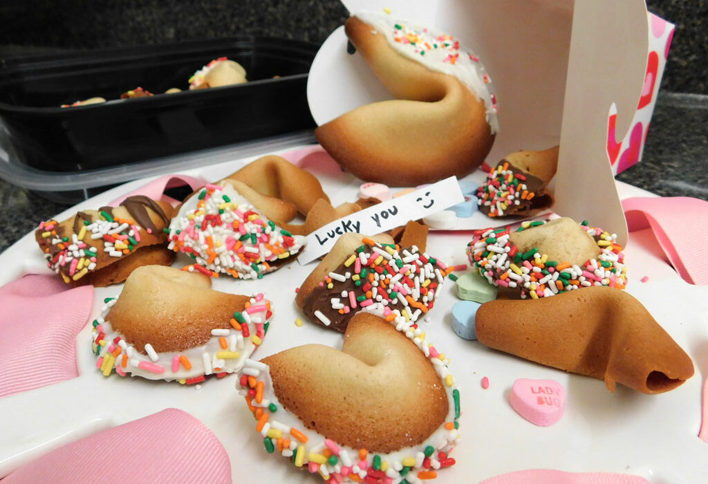 These homemade fortune cookies are decorated for Valentine’s Day with a dip in white chocolate followed by sprinkles. Write your own fortunes or love notes to make them even more special. Staff photo by Jennifer Greenwell